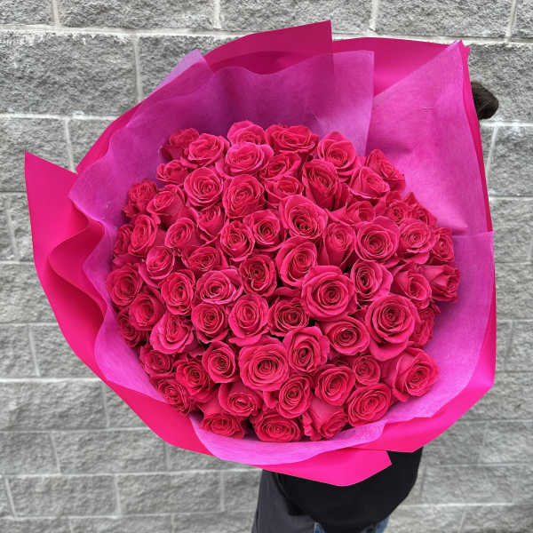 Large bouquet of hot pink roses wrapped in bright pink paper