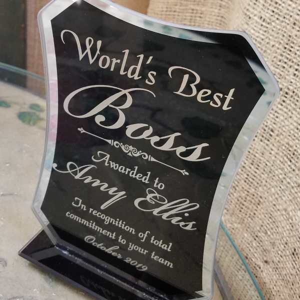 Black acrylic award plaque with silver lettering on a clear base