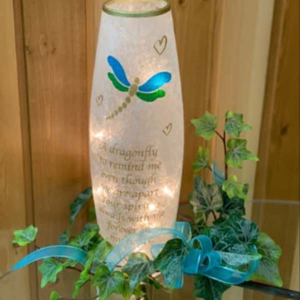 Lit memorial lantern with dragonfly design and ivy garland