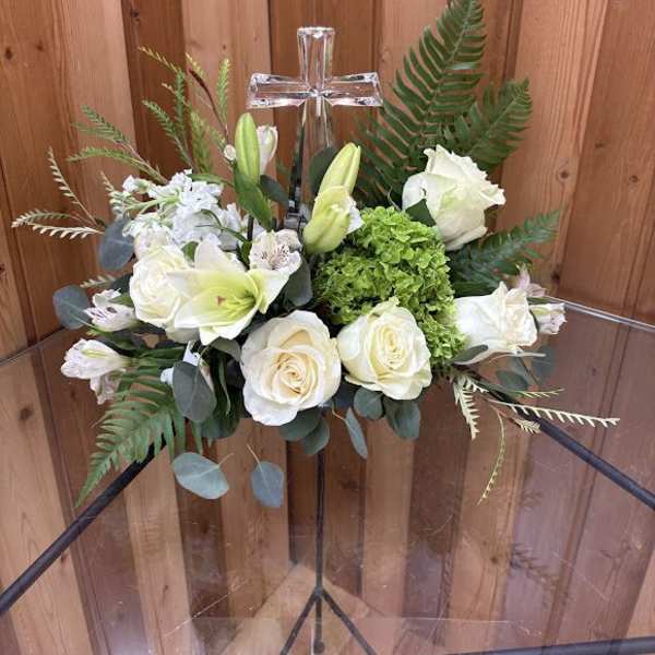 White floral arrangement with a clear cross centerpiece