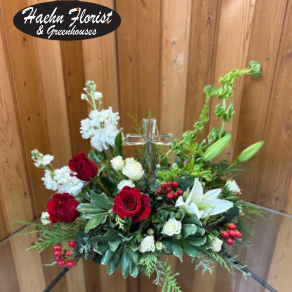 Red and white floral arrangement with a clear glass cross centerpiece