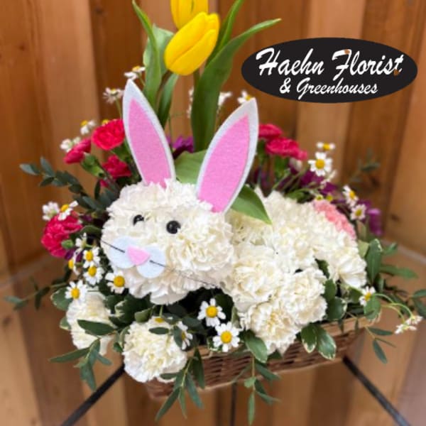 Basket arrangement with a bunny face, pink ears, and yellow tulips