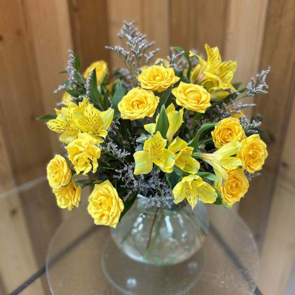 Yellow roses and alstroemeria in a clear glass vase