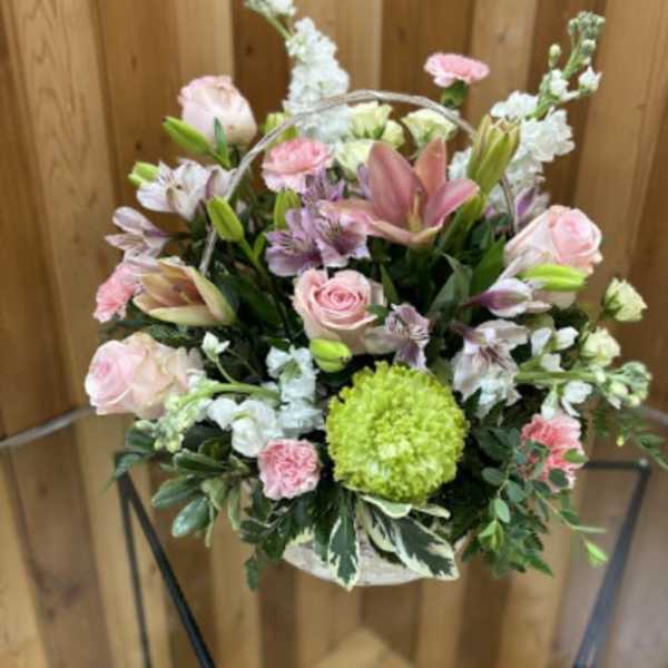 Basket arrangement of pink and white flowers with a green chrysanthemum