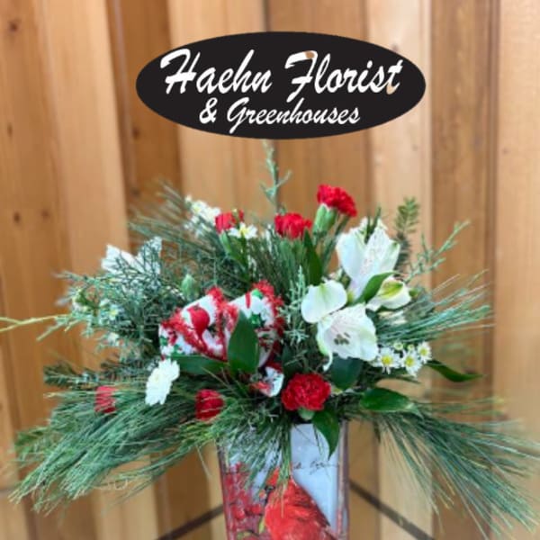 Red and white floral arrangement in a decorative container