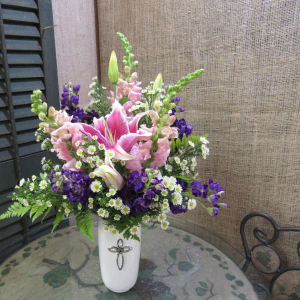 Pink lilies and purple flowers in a white vase