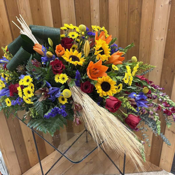 Mixed bouquet with sunflowers, roses, and lilies on a stand