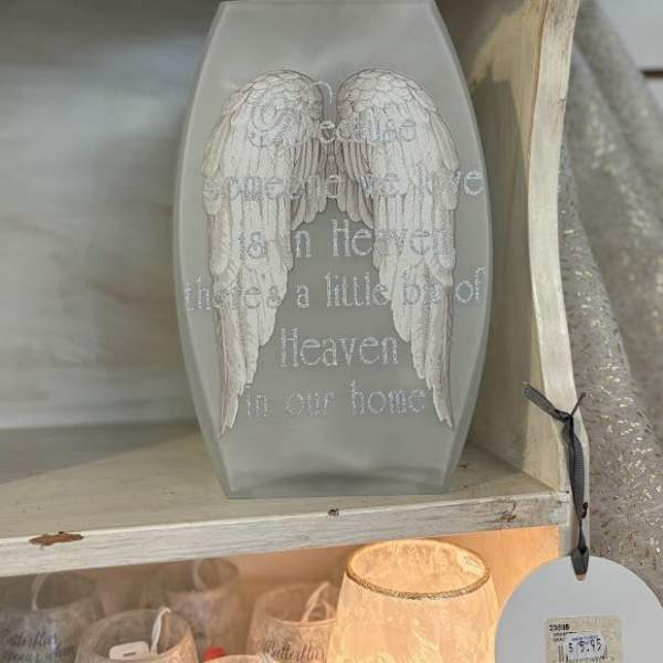 Gray coffin-shaped plaque with white angel wings and memorial text