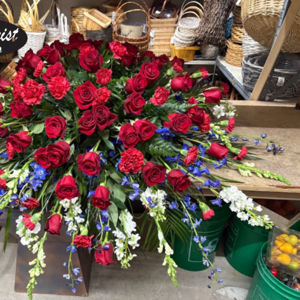 Large red rose arrangement with blue and white flowers in a store display