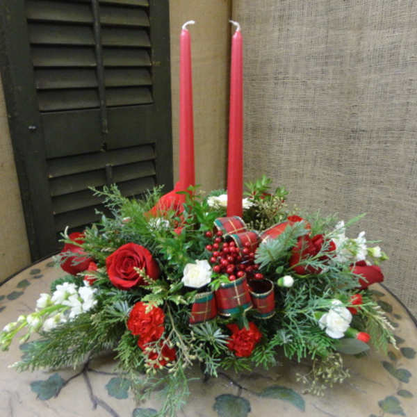 Red and white floral centerpiece with two tall red candles