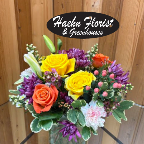 Mixed bouquet of yellow and orange roses in a glass vase