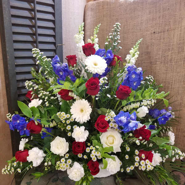 Large mixed bouquet with red and white roses, blue flowers, and white daisies