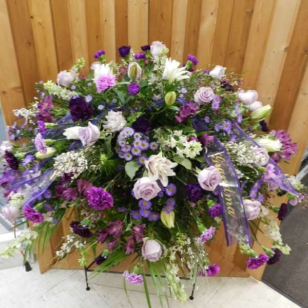 Large purple and white floral spray with ribbon accents