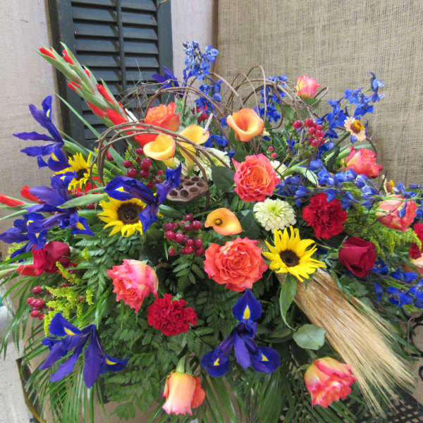 Colorful mixed flower arrangement with roses, irises, sunflowers, and calla lilies