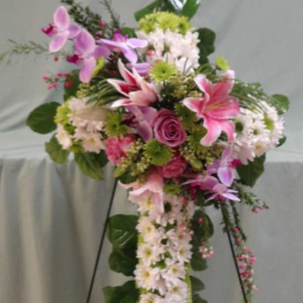 Standing floral spray with pink lilies, orchids, roses, and white daisies