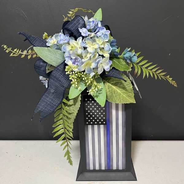 Blue hydrangea arrangement with a thin blue line flag plaque