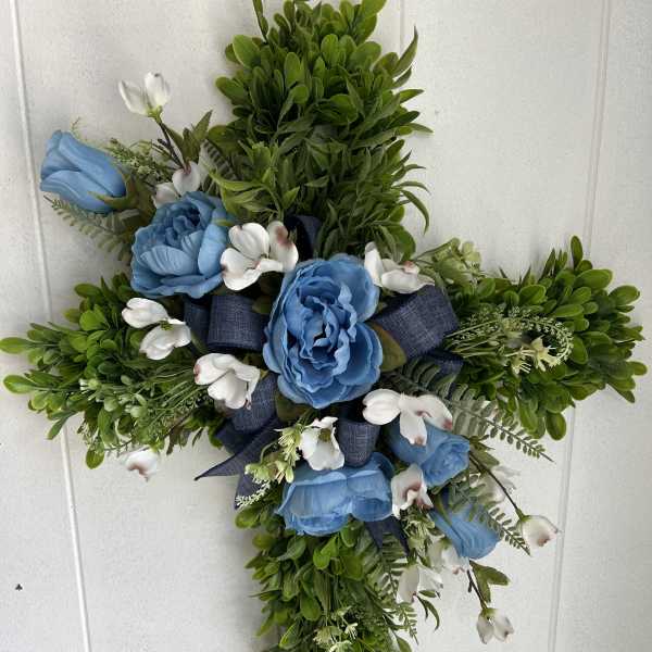 Cross-shaped floral arrangement with blue roses and white blossoms