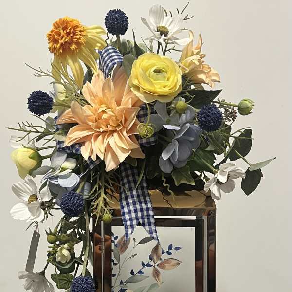 Mixed floral arrangement in a lantern-style frame with a memorial plaque