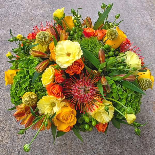 Bright bouquet of yellow, orange, and red flowers with green accents
