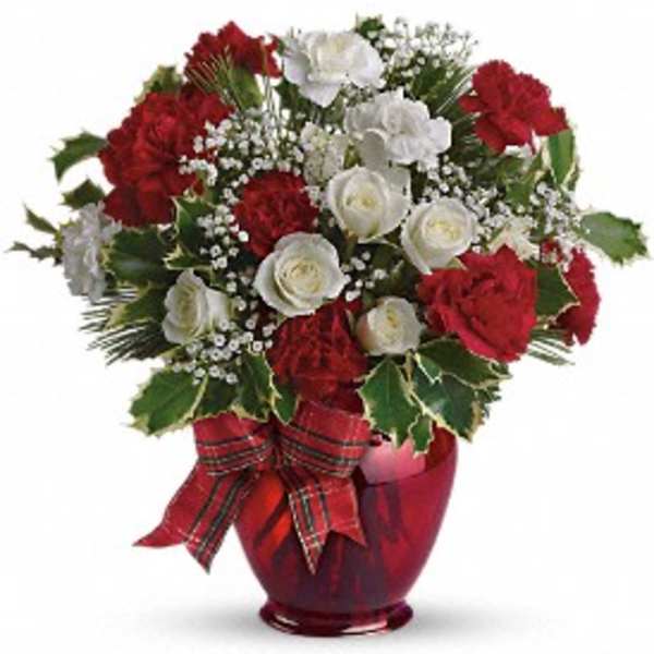Red and white floral arrangement in a red vase with a plaid ribbon