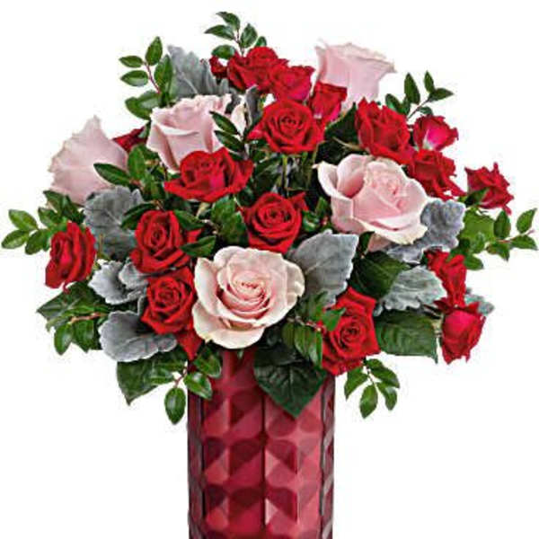 Red and pink roses in a tall red glass vase