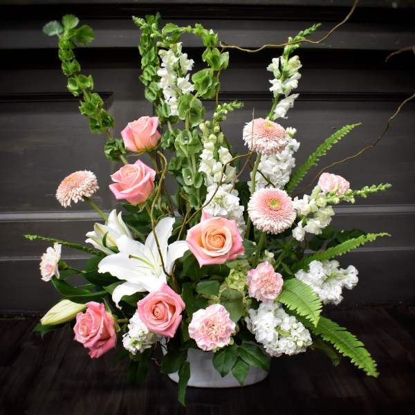 Pink roses and white lilies in a low white container