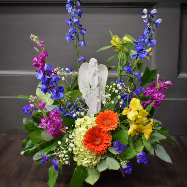 Colorful floral arrangement with an angel figurine in the center