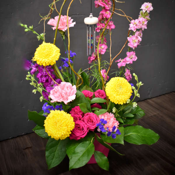 Colorful floral arrangement with roses, carnations, and yellow mums in a vase