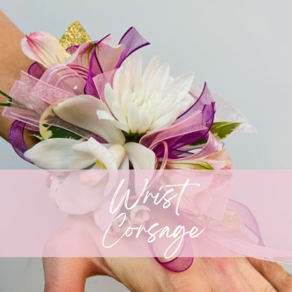 White wrist corsage with pink and purple ribbon accents