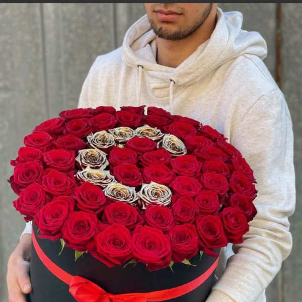 Large round box of red roses with a red ribbon bow