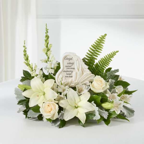 White floral sympathy arrangement with a memorial stone centerpiece