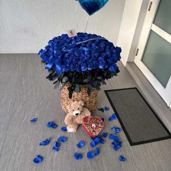 Blue rose arrangement with heart balloons, teddy bear, and candy box