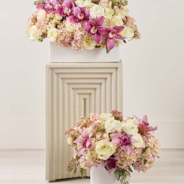 Pink and white floral arrangements in white containers
