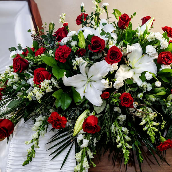 Large red and white floral casket spray with roses and lilies