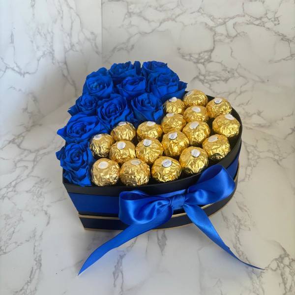 Heart-shaped box with blue roses and gold-wrapped chocolates tied with a blue ribbon