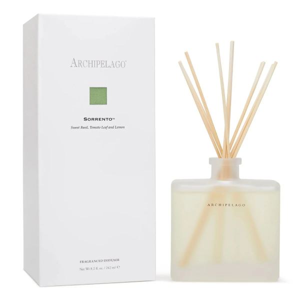 Fragranced diffuser bottle with reed sticks beside its box