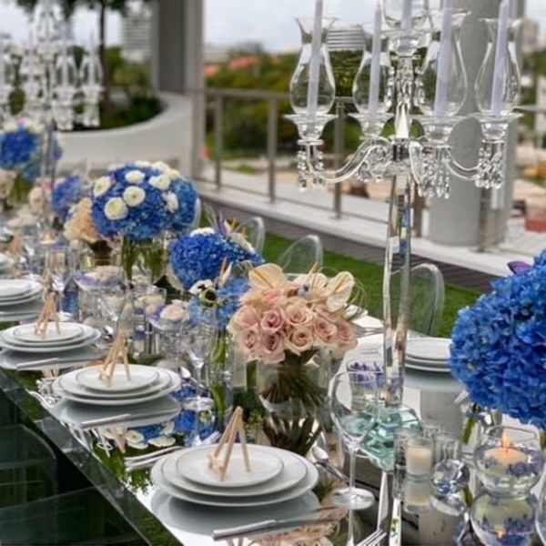 Long banquet table with blue and blush floral centerpieces and crystal candelabras