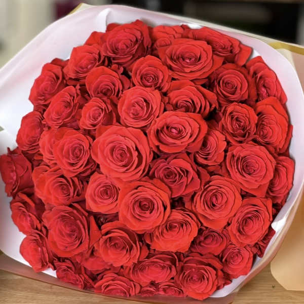 Large bouquet of red roses wrapped in white paper