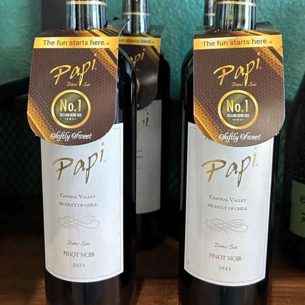 Two bottles of Pinot Noir wine on a shelf