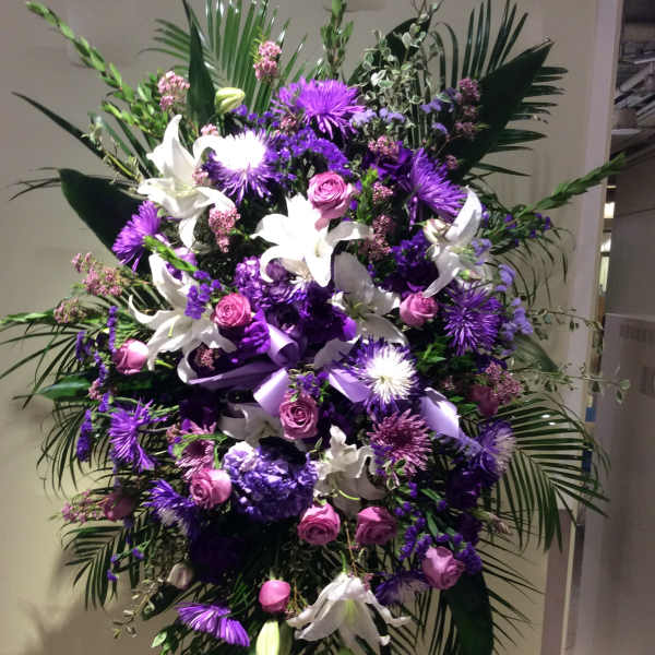 Large purple and white floral standing spray with lilies and roses