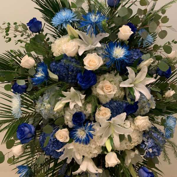 Blue and white floral standing spray with roses and lilies