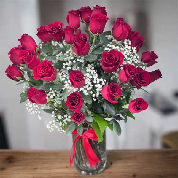 Bouquet of red roses with baby's breath in a glass vase