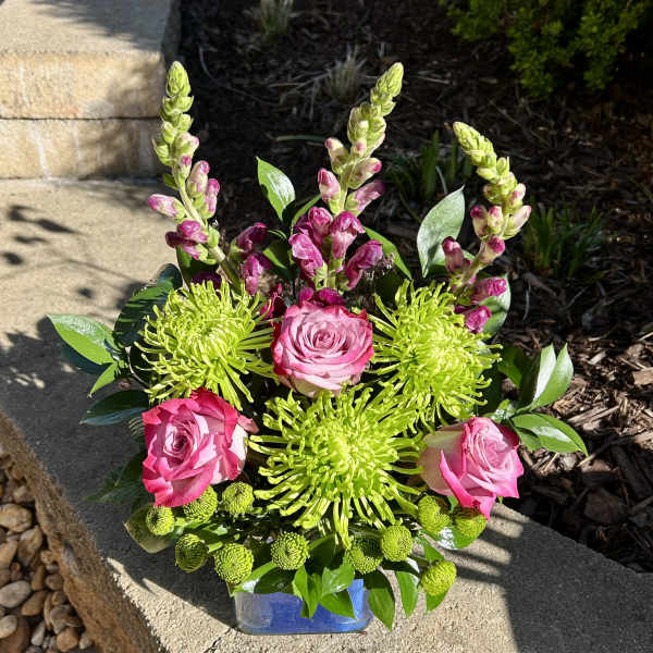 Pink roses and lime-green chrysanthemums in a blue glass vase