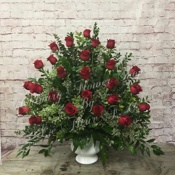 Large arrangement of red roses in a white pedestal vase