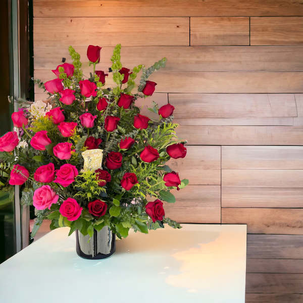 Large bouquet of red and pink roses in a black vase