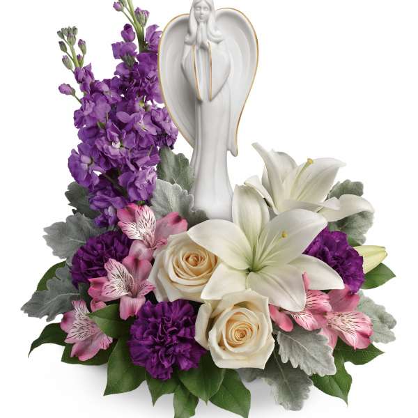 White angel figurine surrounded by purple, pink, and white flowers