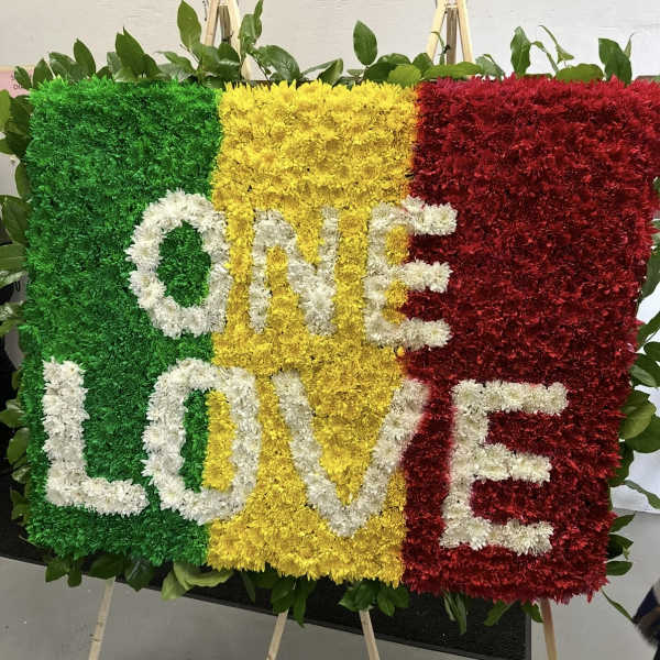 Floral display spelling ONE LOVE in green, yellow, red, and white