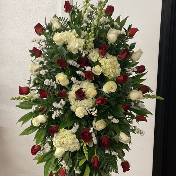 Tall standing floral spray with red and white roses and cream hydrangeas