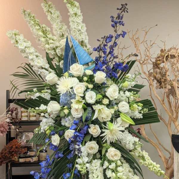 Large standing floral arrangement with white roses and blue flowers
