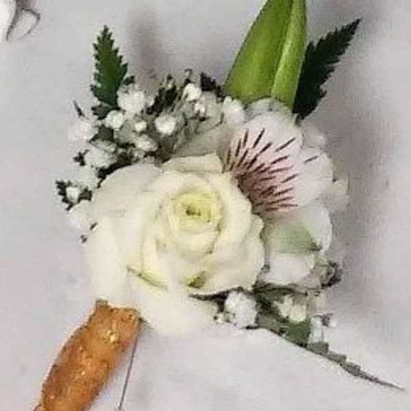 White floral boutonniere with a green bud and small white accents